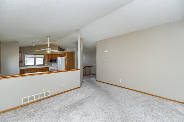 2625 Westview Ln NW, Rochester, MN 55901 - unfurnished living room featuring visible vents, baseboards, ceiling fan, lofted ceiling, and light colored carpet
