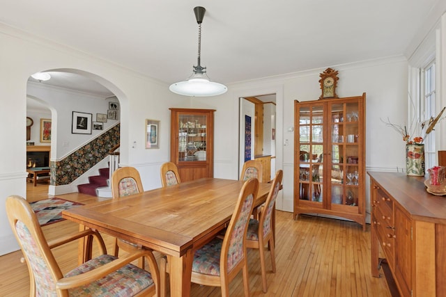 2924 Farwell Ave, Minneapolis, MN 55411 - dining room with light wood-style flooring, stairs, ornamental molding, and arched walkways