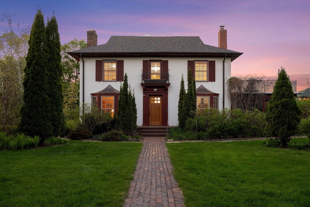 2924 Farwell Ave, Minneapolis, MN 55411 - view of front of house featuring a balcony, a chimney, a lawn, and stucco siding