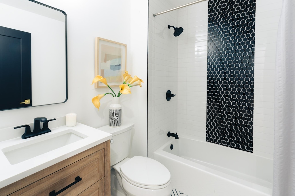 bathroom featuring toilet, shower / washtub combination, and vanity