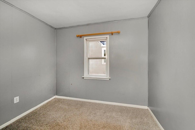 carpeted empty room featuring baseboards