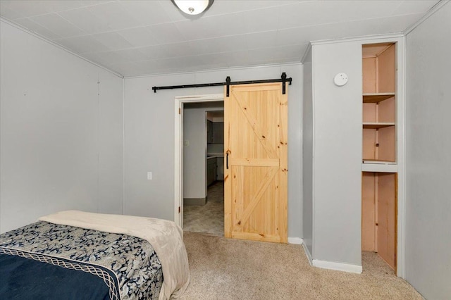 bedroom featuring a barn door, carpet flooring, and baseboards