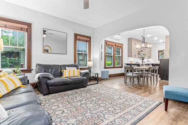 1597 James Ave, Saint Paul, MN 55105 - living room featuring a ceiling fan, radiator, arched walkways, and light wood-type flooring