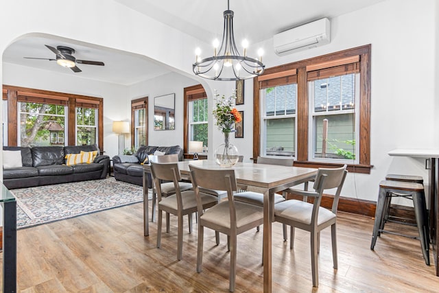1597 James Ave, Saint Paul, MN 55105 - dining room featuring a wall mounted air conditioner, light wood finished floors, healthy amount of natural light, and arched walkways