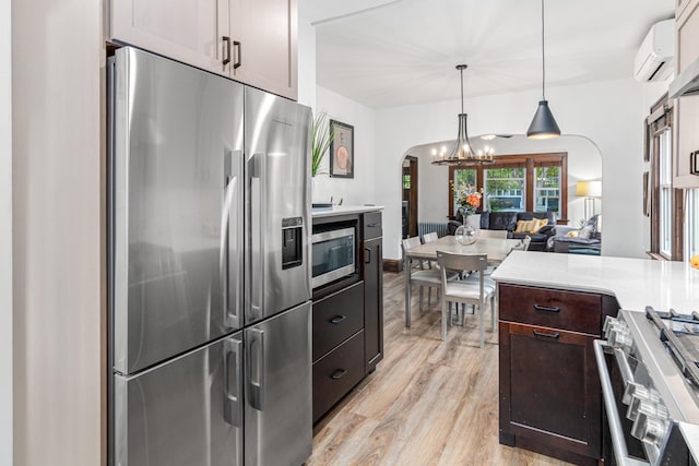 1597 James Ave, Saint Paul, MN 55105 - kitchen featuring stainless steel appliances, arched walkways, light wood-style floors, a chandelier, and dark brown cabinets