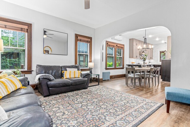 1597 James Ave, Saint Paul, MN 55105 - living area with radiator heating unit, a ceiling fan, arched walkways, and light wood-style flooring