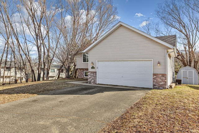 view of home's exterior with a shed, an outbuilding, an attached garage, brick siding, and aphalt driveway