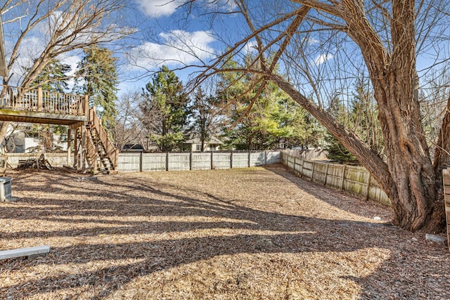 view of yard with stairs, a fenced backyard, and a deck
