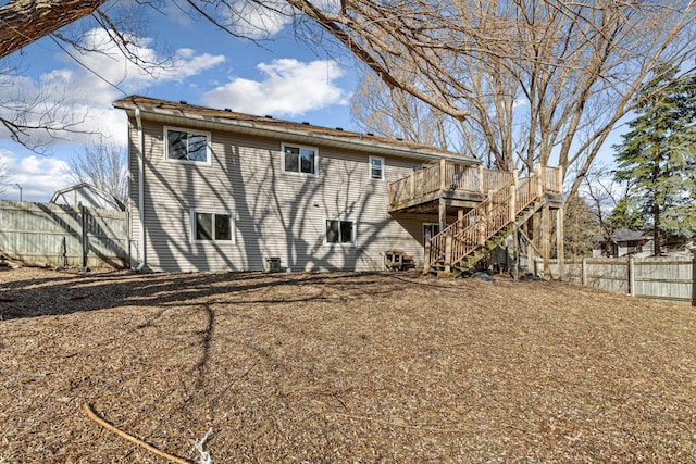 back of property with stairs, a deck, and fence