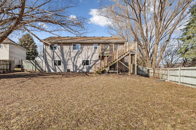 rear view of property with a fenced backyard, stairs, and a wooden deck