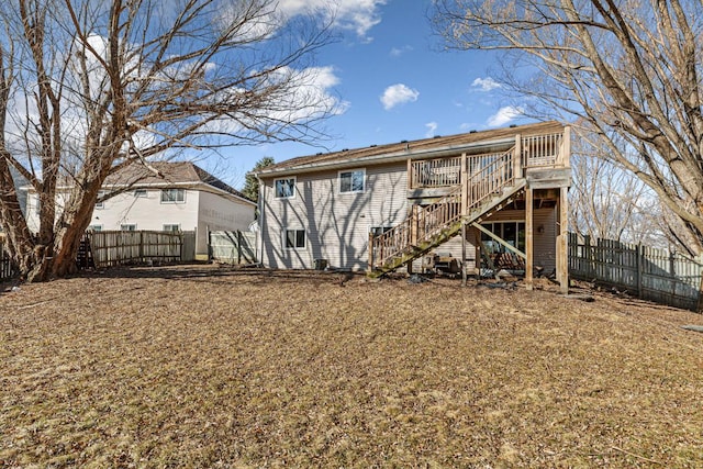 back of house featuring stairs, a deck, and fence