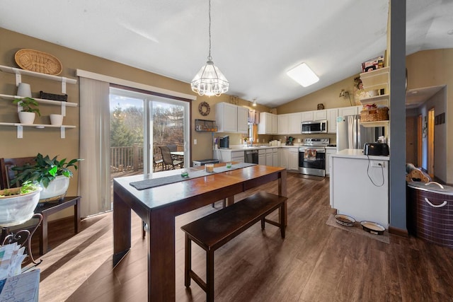 dining room with lofted ceiling, dark wood-style floors, and a chandelier