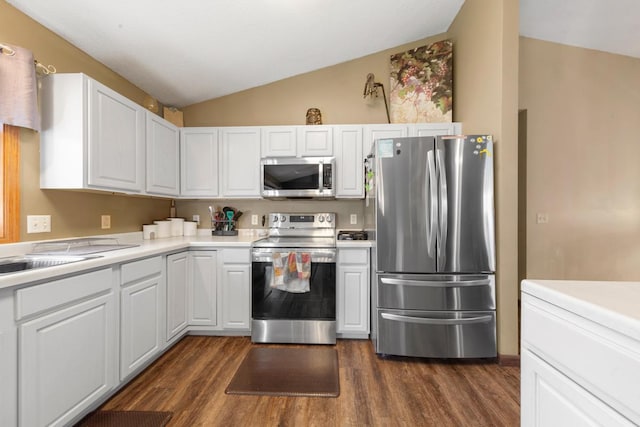 kitchen featuring white cabinets, light countertops, stainless steel appliances, dark wood finished floors, and lofted ceiling
