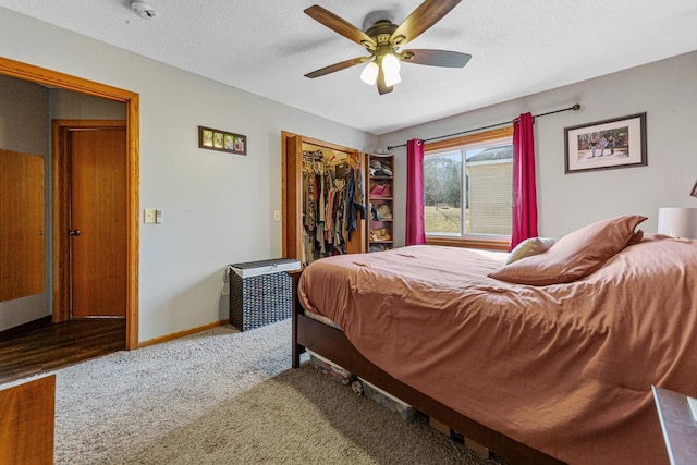 carpeted bedroom featuring a closet, a textured ceiling, baseboards, and ceiling fan