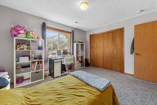 bedroom featuring a closet, carpet floors, a textured ceiling, baseboards, and visible vents