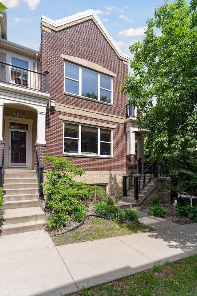 13 4th Ave N Unit 106, Minneapolis, MN 55401 - view of front facade featuring brick siding, a balcony, and stairs