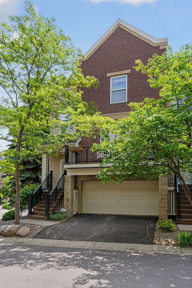 13 4th Ave N Unit 106, Minneapolis, MN 55401 - view of front of property featuring stairway, brick siding, driveway, and an attached garage