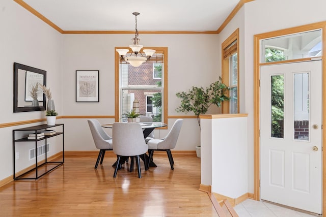 13 4th Ave N Unit 106, Minneapolis, MN 55401 - dining space with a chandelier, healthy amount of natural light, light wood-type flooring, crown molding, and baseboards