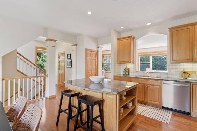 13 4th Ave N Unit 106, Minneapolis, MN 55401 - kitchen with stainless steel dishwasher, a sink, backsplash, open shelves, and light wood-style floors