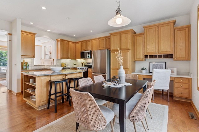 13 4th Ave N Unit 106, Minneapolis, MN 55401 - dining space with light wood-style floors, recessed lighting, arched walkways, and baseboards