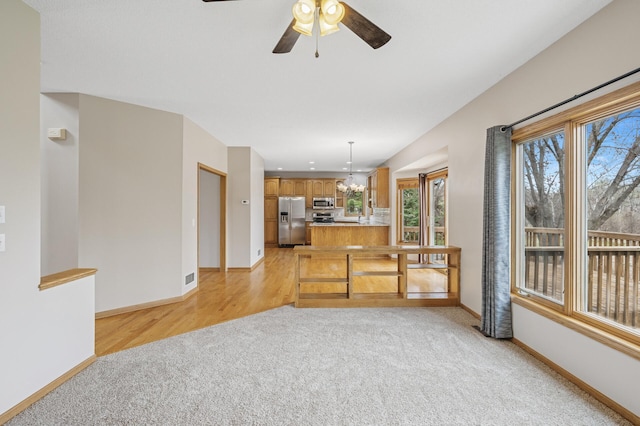 unfurnished living room with baseboards, a ceiling fan, and light carpet