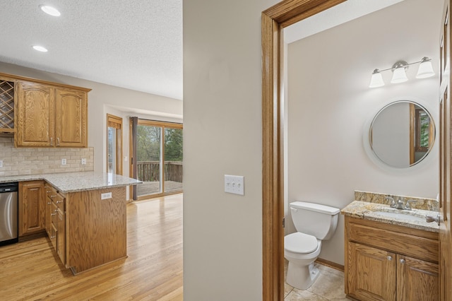 interior space featuring a textured ceiling, tasteful backsplash, toilet, recessed lighting, and vanity