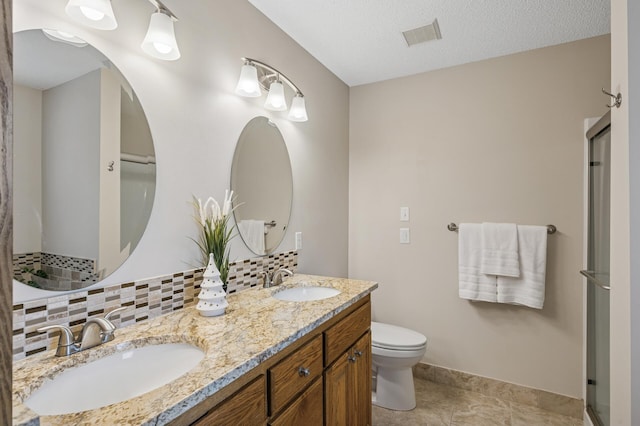 full bathroom featuring double vanity, toilet, backsplash, and a sink