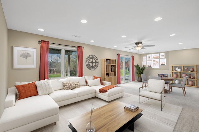 living area featuring recessed lighting, visible vents, ceiling fan, and light carpet