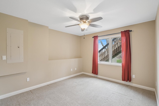 carpeted empty room featuring electric panel, ceiling fan, and baseboards