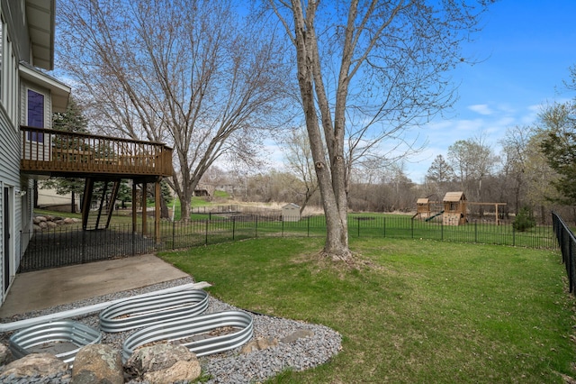 view of yard featuring a fenced backyard, a wooden deck, and a playground