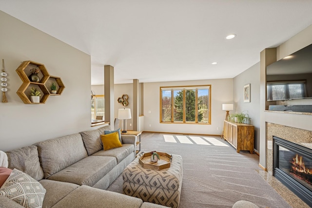 carpeted living area featuring a glass covered fireplace, recessed lighting, and baseboards