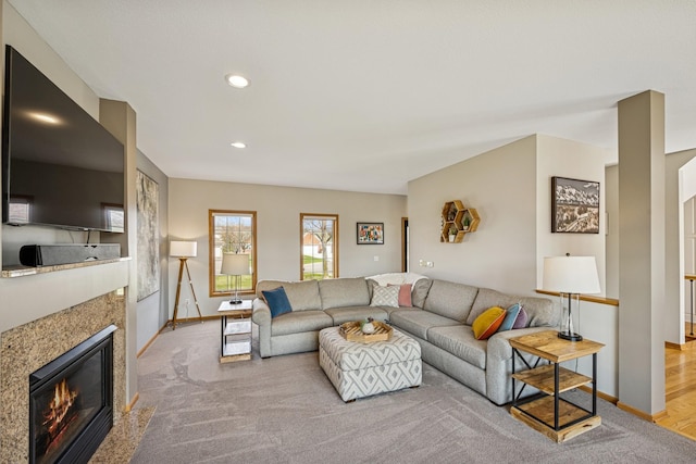 living room with a high end fireplace, recessed lighting, carpet floors, and baseboards