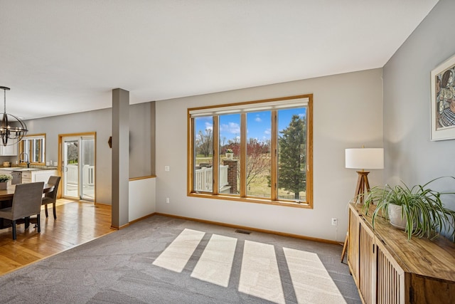 interior space with a chandelier, baseboards, and visible vents