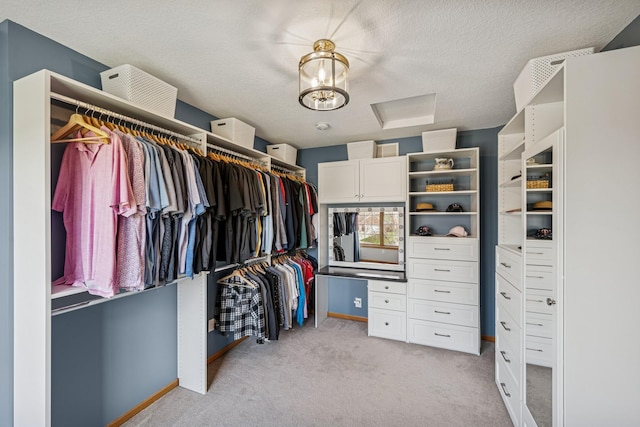 spacious closet featuring attic access and light colored carpet