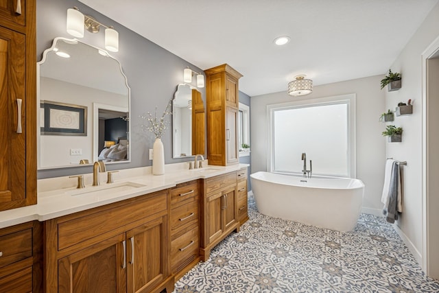 full bath with recessed lighting, double vanity, a sink, and a soaking tub
