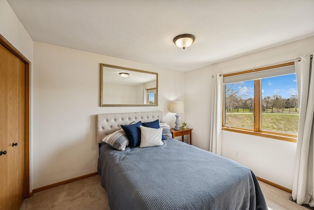 bedroom with baseboards, carpet floors, and a closet