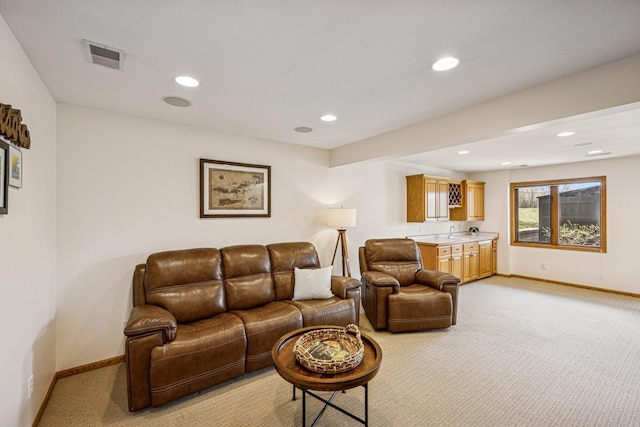 living room with recessed lighting, light carpet, and baseboards