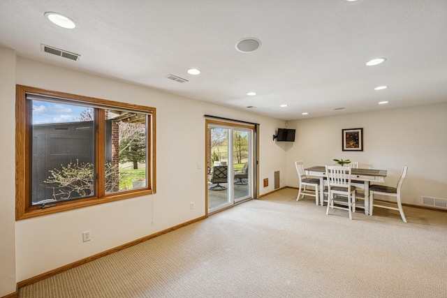 dining space with visible vents, baseboards, and light carpet