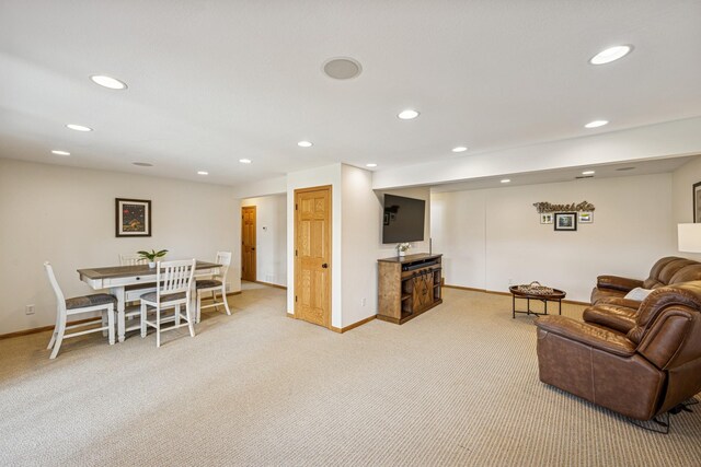 living area with recessed lighting and light carpet
