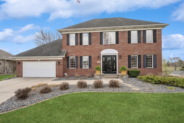 view of front of home with brick siding, a shingled roof, a garage, driveway, and a front yard