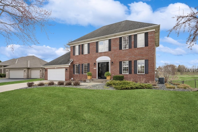 view of front of home with brick siding, a front lawn, driveway, and an attached garage