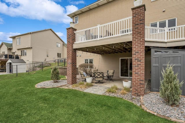 rear view of property with a patio, an outdoor living space, fence, and a yard