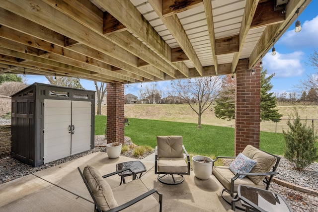 view of patio / terrace with a storage unit, fence, and an outbuilding