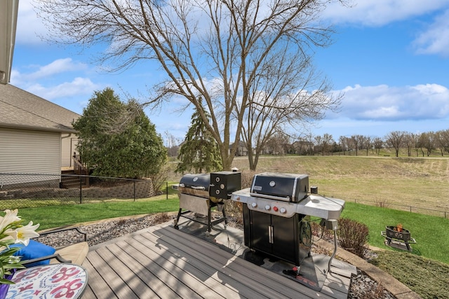 wooden terrace featuring a lawn, area for grilling, fence, and an outdoor fire pit