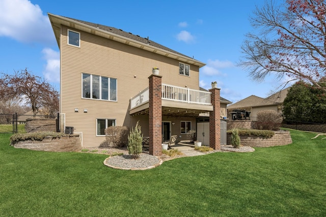rear view of property with a wooden deck, a yard, and fence
