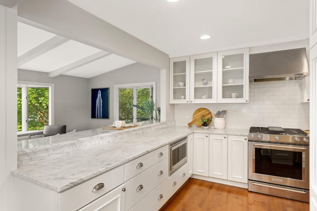 1310 Vine Pl, Orono, MN 55364 - kitchen with stainless steel appliances, wall chimney range hood, a peninsula, tasteful backsplash, and recessed lighting