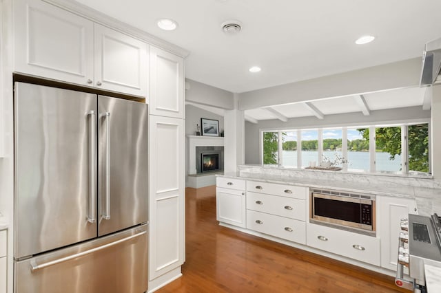 1310 Vine Pl, Orono, MN 55364 - kitchen featuring stainless steel appliances, beamed ceiling, wood finished floors, white cabinets, and recessed lighting