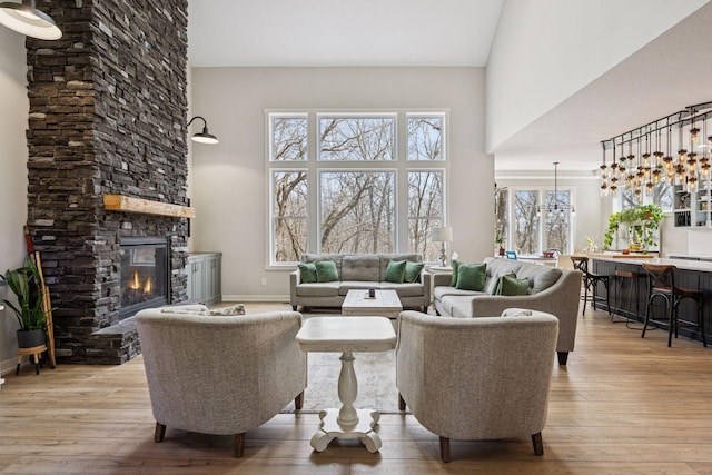 18837 Ogden St NW, Elk River, MN 55330 - living room featuring a high ceiling, a fireplace, light wood-type flooring, and baseboards