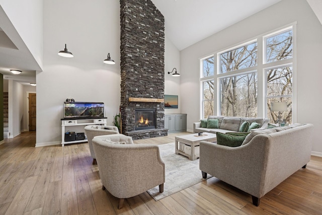 18837 Ogden St NW, Elk River, MN 55330 - living room featuring high vaulted ceiling, a stone fireplace, hardwood / wood-style flooring, and baseboards