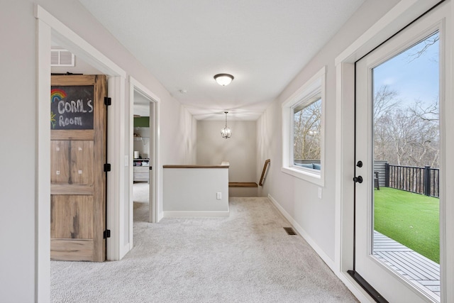 18837 Ogden St NW, Elk River, MN 55330 - hallway featuring carpet, an upstairs landing, baseboards, and a chandelier